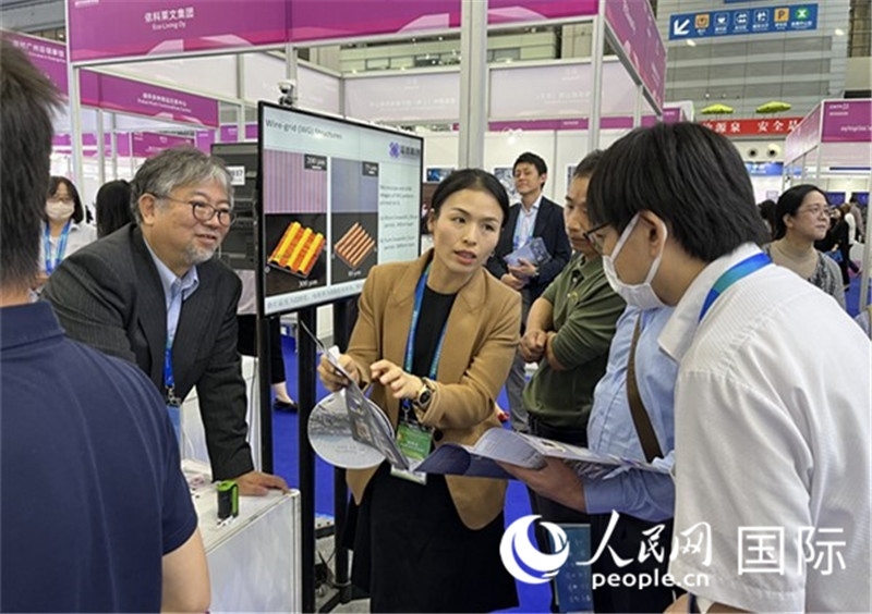 工作人員向參觀者介紹超級噴墨技術(shù)。（人民網(wǎng)記者 陳思攝）