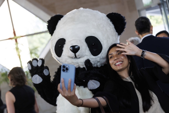2022年8月24日，在美國華盛頓中國駐美國大使館，來賓與大熊貓玩偶合影。