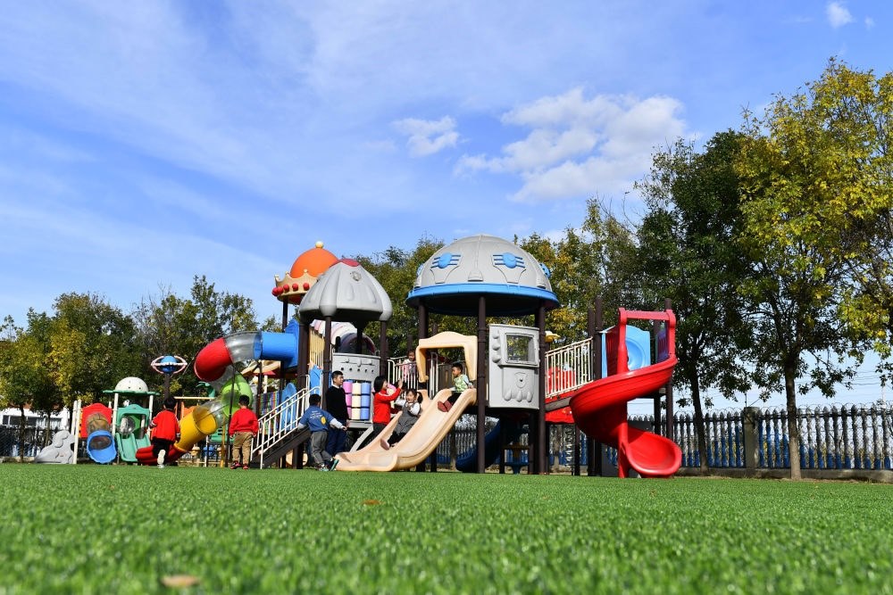 在山東省東營(yíng)市墾利區(qū)楊廟社區(qū)幼兒園，孩子們?cè)诶蠋煹膸ьI(lǐng)下進(jìn)行戶外活動(dòng)（2021年10月19日攝）。新華社記者 郭緒雷 攝