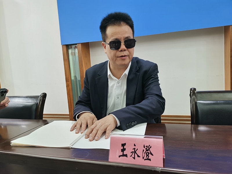 全國人大代表王永澄正在閱讀盲文版代表建議答復。本報記者 張 璁攝