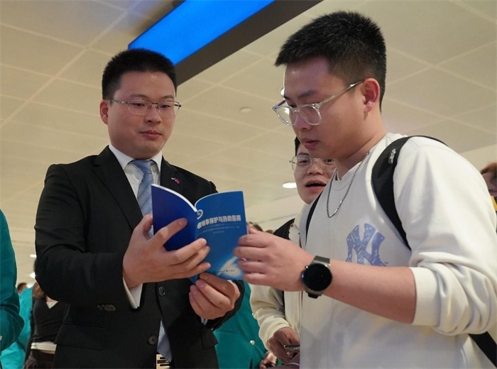 工作人員（左一）在發(fā)放《中國領(lǐng)事保護(hù)與協(xié)助指南》。 中國駐迪拜總領(lǐng)事館供圖