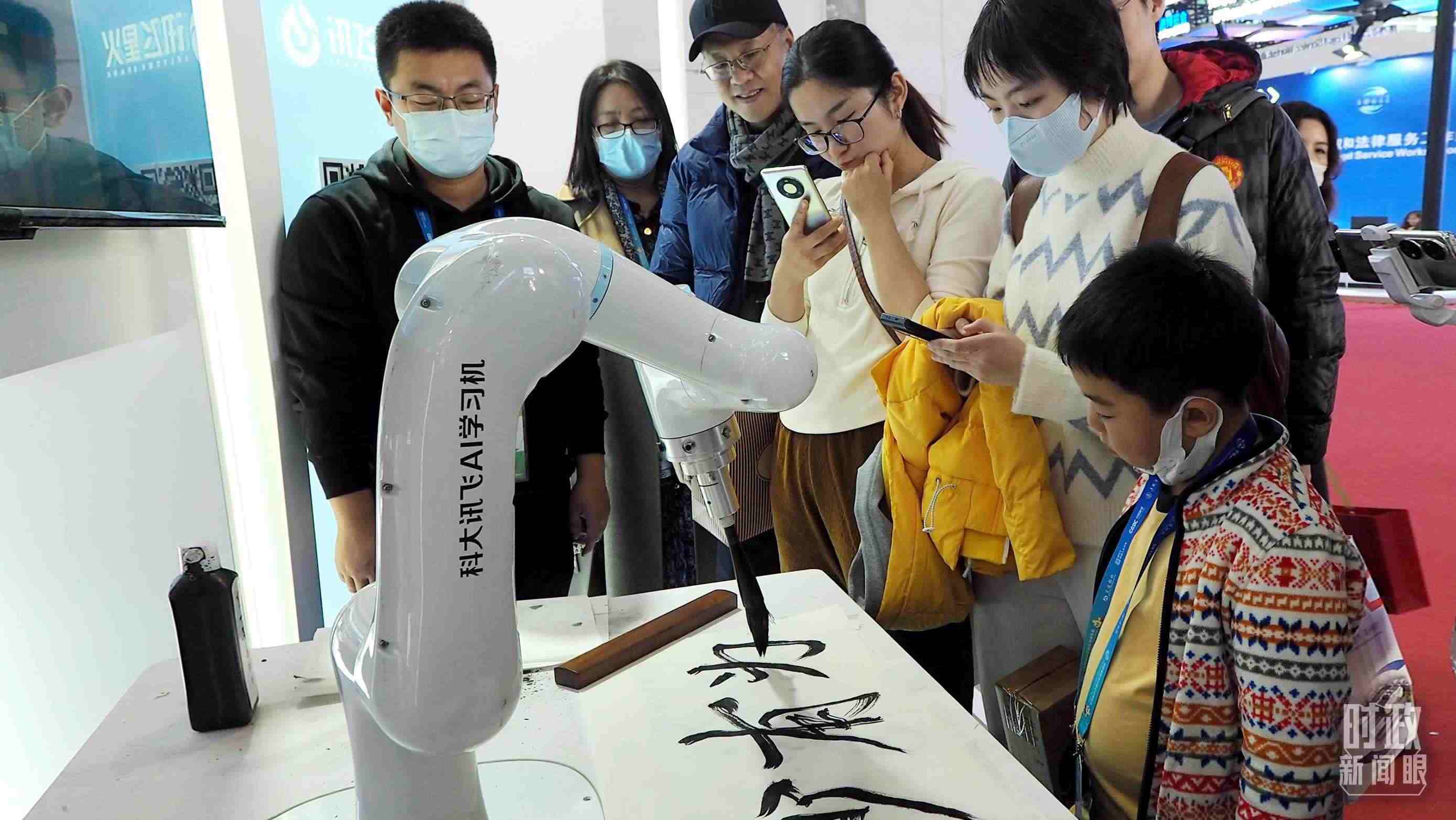 △觀眾在首屆鏈博會(huì)上體驗(yàn)AI書(shū)法機(jī)器人。