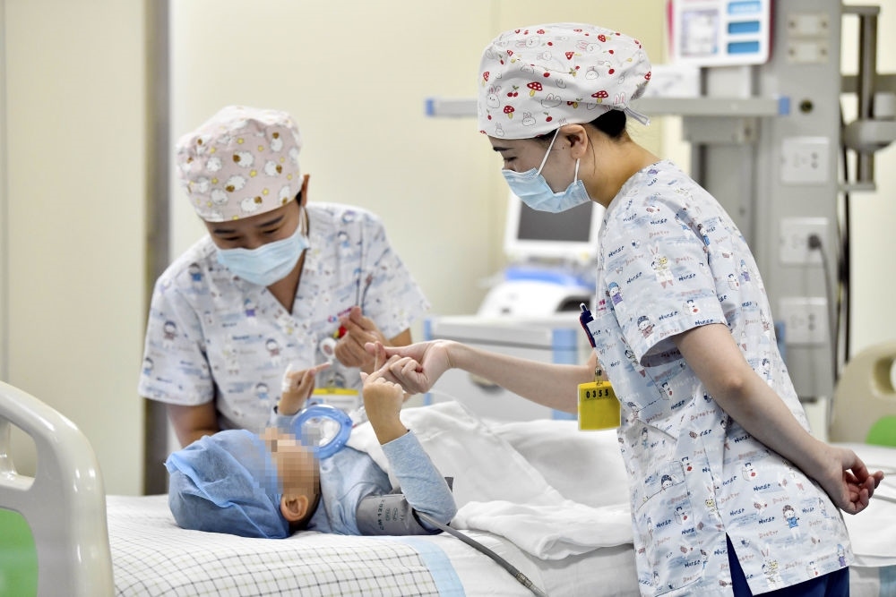 在山東省棗莊市婦幼保健院兒童ICU病房，醫(yī)護(hù)人員為完成靶向治療藥物諾西那生鈉的4歲脊髓性肌萎縮癥患兒加油鼓勁（2022年1月1日攝）。諾西那生鈉注射液是我國首個獲批治療脊髓性肌萎縮癥的進(jìn)口藥物，2019年進(jìn)入中國市場時，每針價格近70萬元。在2021年國家醫(yī)保目錄藥品談判中，以3.3萬元每針的價格進(jìn)入新版醫(yī)保藥品目錄。新華社記者 郭緒雷 攝