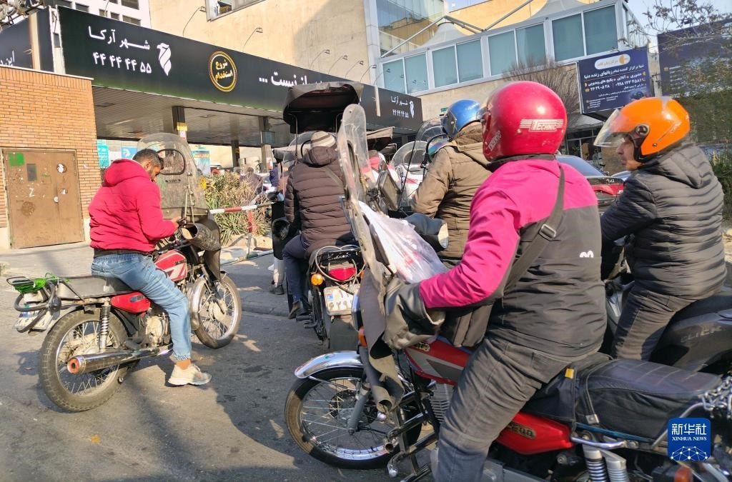 12月18日，摩托車在伊朗首都德黑蘭的一家加油站外等待加油。新華社記者 沙達(dá)提 攝