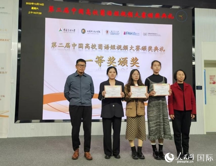 澳門大學(xué)中葡雙語教學(xué)暨培訓(xùn)中心主任姚京明（左一）和中國傳媒大學(xué)外國語言文化學(xué)院院長文春英（右一）為一等獎獲得者頒獎。人民網(wǎng)記者 魯揚(yáng)攝