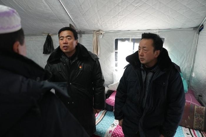 2023年12月22日，積石山縣大河家鎮(zhèn)大河村黨支部書記馬成忠（右二）在帳篷里和受災(zāi)群眾交流。新華社記者 陳斌 攝