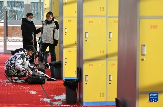 12月21日，游客在滑雪服務(wù)大廳整理滑雪裝備。