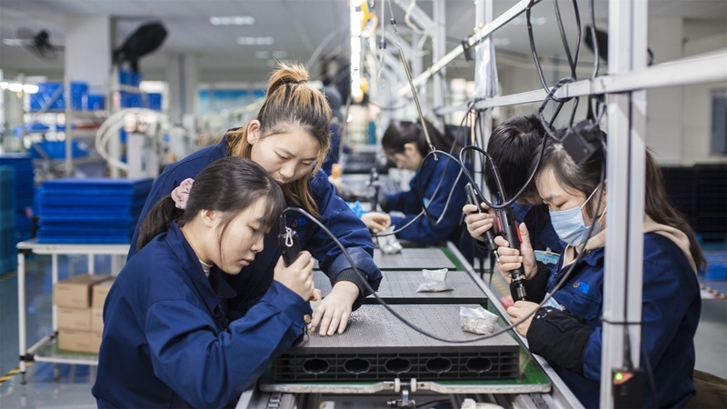 在新亞勝光電的產(chǎn)品線上，工人正進(jìn)行產(chǎn)品組建和安裝布線。受訪者供圖