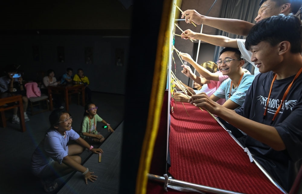 2023年8月8日，進(jìn)行暑期研學(xué)的學(xué)生在位于陜西省西安市的中國(guó)秦腔藝術(shù)博物館體驗(yàn)皮影戲演出。新華社記者 鄒競(jìng)一 攝