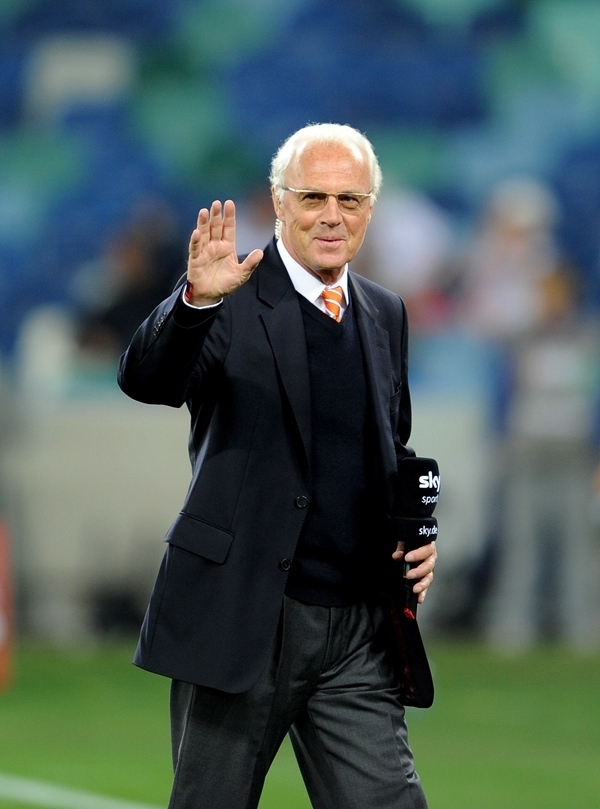 這是2010年7月7日，在南非德班舉行的2010年足球世界杯德國隊(duì)對(duì)陣西班牙隊(duì)的半決賽前，貝肯鮑爾接受電視臺(tái)采訪時(shí)和友人打招呼。新華社記者 王毓國 攝