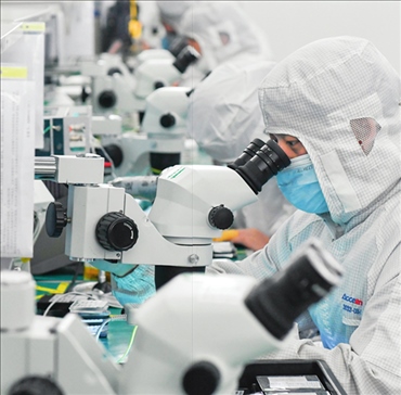 在位于武漢中國光谷的光電器件研發(fā)制造商——武漢光迅科技股份有限公司生產(chǎn)車間內(nèi)，技術(shù)人員在光模塊生產(chǎn)線作業(yè)（2023年4月11日攝）。程敏攝/本刊