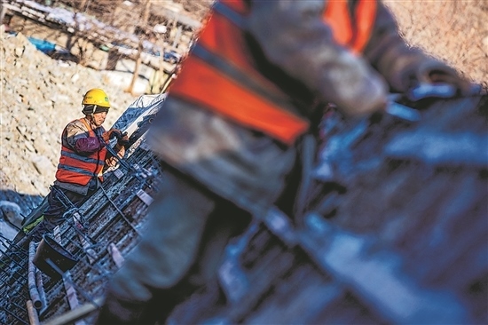 1月3日，房山區(qū)，工人正在雙泉河修筑堤壩。