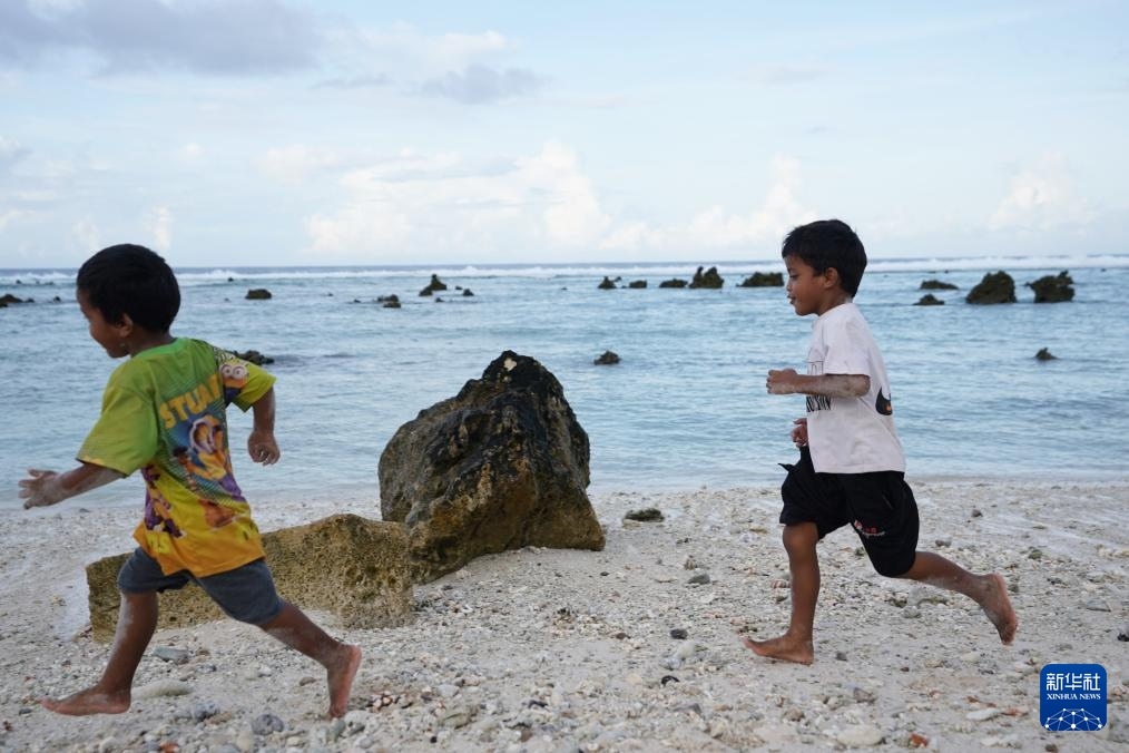 1月20日，兒童在瑙魯海邊嬉戲。新華社記者 王申 攝