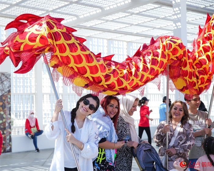 游客體驗舞龍。 人民網(wǎng) 塔里克·易卜拉欣攝