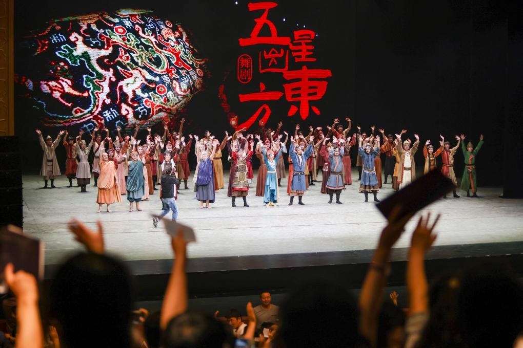 2023年7月31日，新疆和田地區(qū)新玉歌舞團在烏魯木齊京劇院演出舞劇《五星出東方》后和觀眾互相揮手致意。這場演出是第六屆中國新疆國際民族舞蹈節(jié)的參演劇目之一，曾榮獲國家“文華獎”等。新華社記者 郝昭 攝
