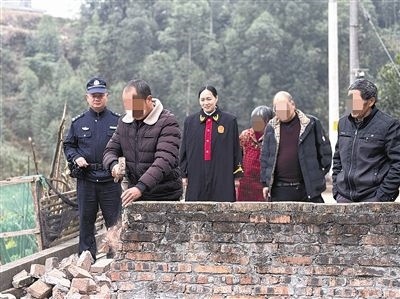  圖③：庭審結(jié)束后，在法官的見證下，陳某在院壩邊重新開鑿一條通道。