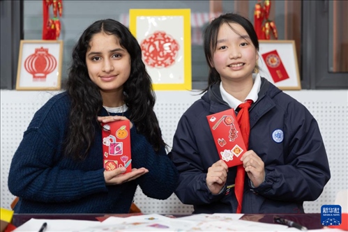 1月28日，美國馬斯卡廷中學(xué)學(xué)生（左）和復(fù)旦大學(xué)第二附屬學(xué)校學(xué)生展示互相送出的寫有寄語祝福的紅包。 新華社記者 王翔 攝