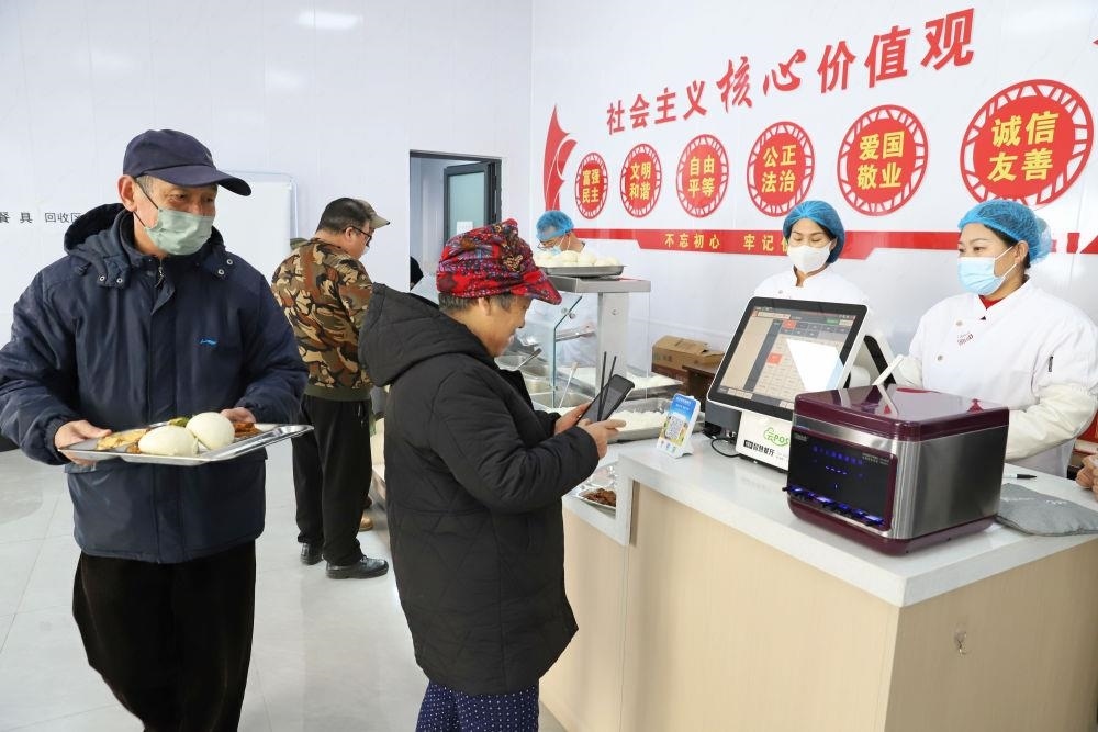 △2024年2月1日，市民在河北涿州市雙塔街道永濟(jì)秀園小區(qū)便民食堂內(nèi)購買午餐。