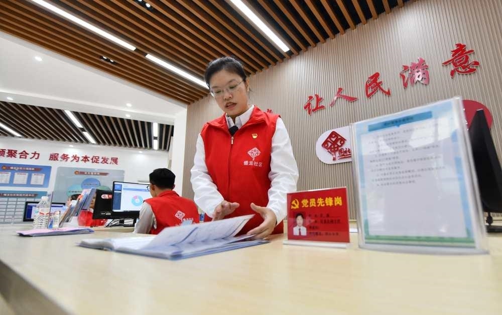 △2023年12月14日，廣西南寧市蟠龍社區(qū)，工作人員在為居民服務(wù)。