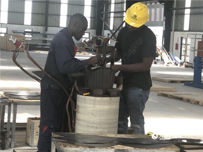 經(jīng)貿(mào)合作區(qū)廠房內(nèi)，當(dāng)?shù)毓と苏诰o張作業(yè)。人民網(wǎng)記者 黃培昭攝