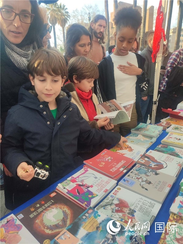 印刷精美的中國傳統(tǒng)文化叢書吸引了小游客的注意。人民網(wǎng)記者鄭彬攝