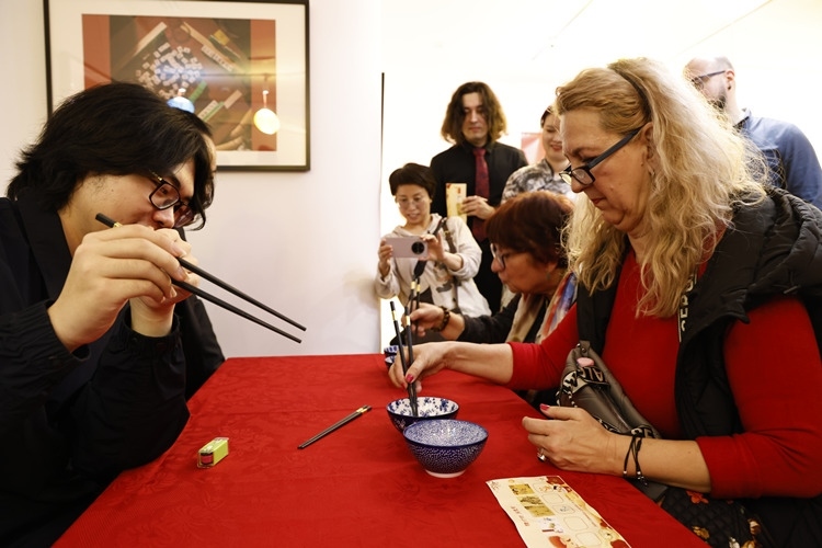 羅馬尼亞觀眾體驗用筷子夾花生。中國文化中心供圖