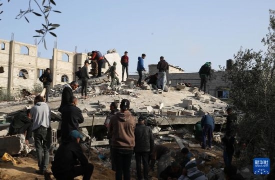  3月3日，在加沙地帶南部城市拉法，人們查看被以軍空襲破壞的建筑。新華社發(fā)（哈立德·奧馬爾攝）