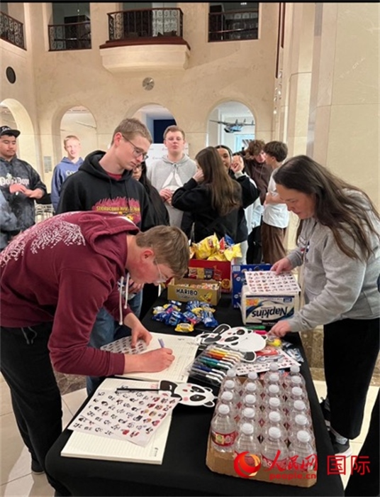 學生們出發(fā)前紛紛在留言簿留言。人民網(wǎng)記者 鄧圩攝