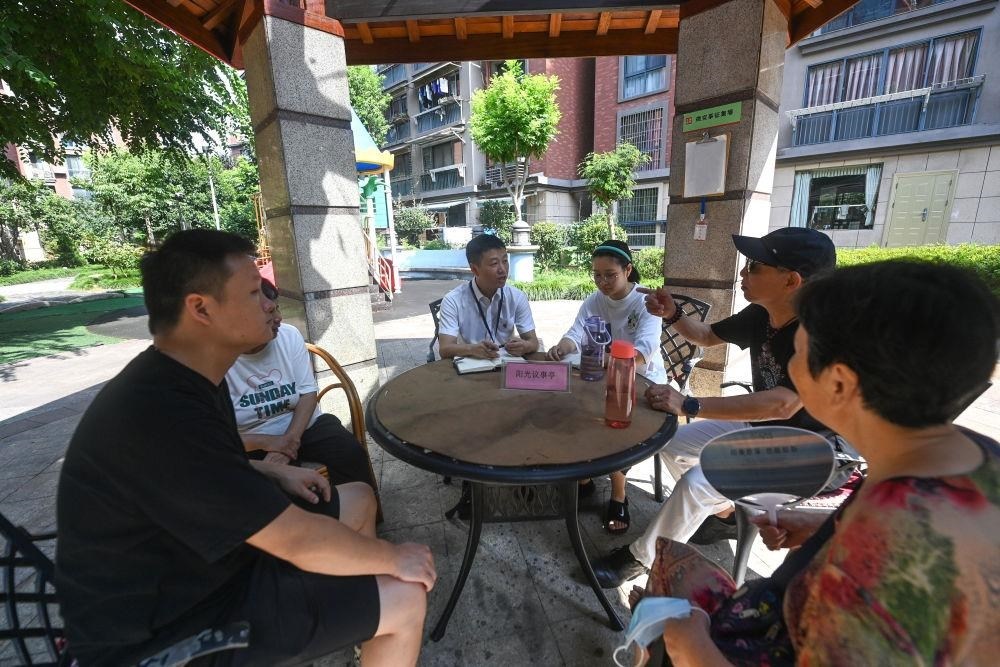 △2023年7月21日，在位于浙江杭州臨安區(qū)錦南街道水岸陽光小區(qū)的陽光議事廳，街道干部在聽取居民們反映的問題及意見。
