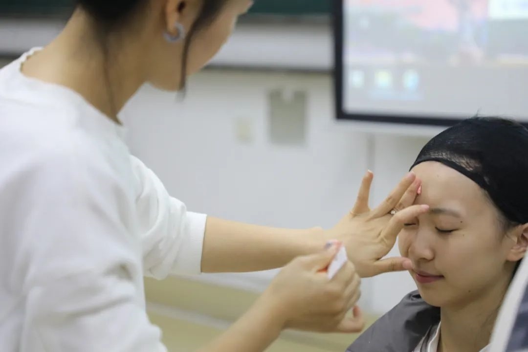 課堂上，一名學生在體驗上戲妝。學校供圖