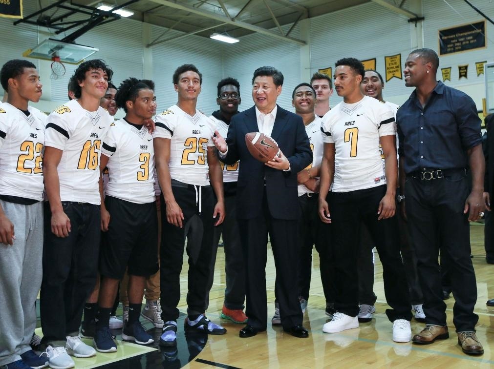 2015年9月23日，國家主席習(xí)近平參觀美國塔科馬市林肯中學(xué)。這是習(xí)近平在學(xué)校體育館，同上橄欖球訓(xùn)練課的學(xué)生們親切交談。新華社記者 蘭紅光 攝