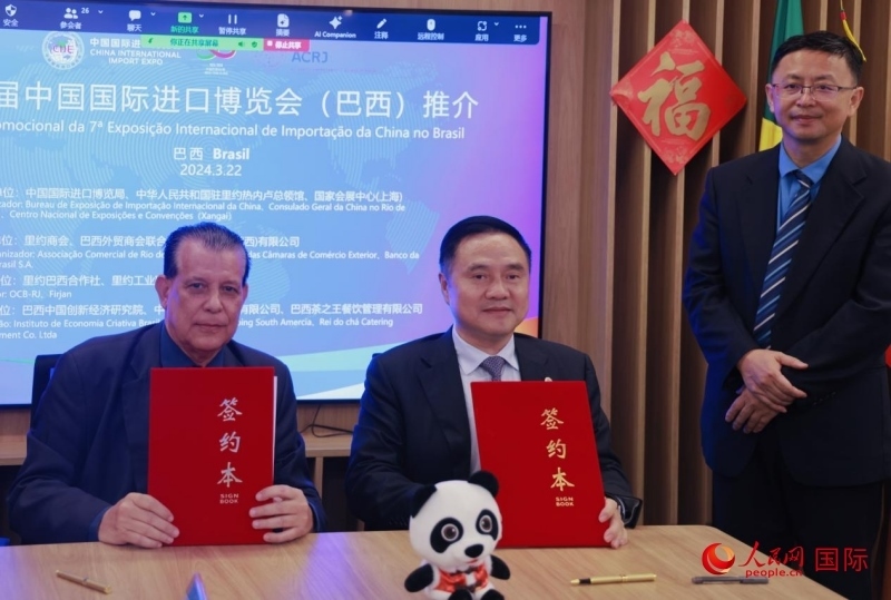巴西外貿(mào)商會(huì)聯(lián)合會(huì)會(huì)長(zhǎng)阿代爾·羅伯托（左）與中國(guó)國(guó)際進(jìn)口博覽局副局長(zhǎng)吳政平（中）現(xiàn)場(chǎng)簽訂協(xié)議。人民網(wǎng)記者 宋亦然攝