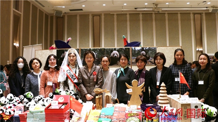 中國駐日本大使吳江浩夫人丁玥（左五）與使館人員在展位前合影留念。人民網(wǎng) 許可攝