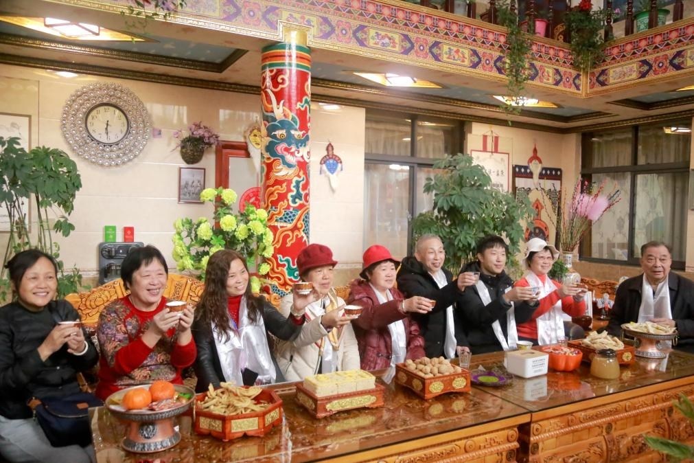 游客們?nèi)胱∶袼藓?，舉杯共飲酥油茶。新華社記者 邱星翔 攝