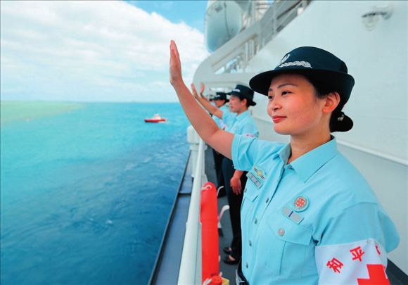 中國海軍“和平方舟”號醫(yī)院船結(jié)束訪問湯加時，任務(wù)官兵中的文職人員向歡送人群揮手告別（2023年8月4日攝）。徐巍攝/本刊