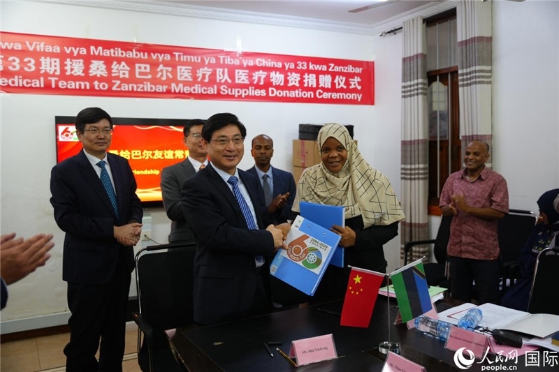 江蘇省蘇北人民醫(yī)院黨委書記束余聲與桑衛(wèi)生部首席秘書哈比巴交換捐贈書。中國援桑醫(yī)療隊(duì)供圖