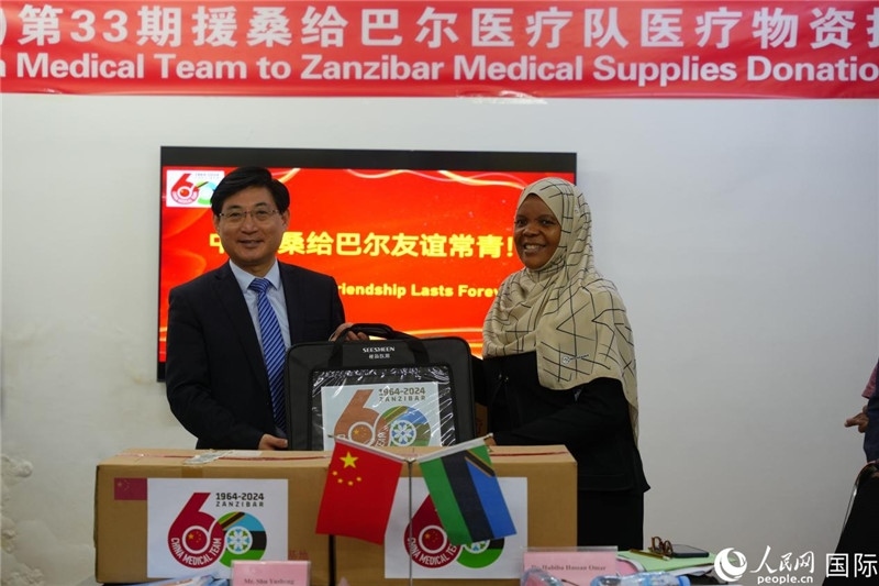 江蘇省蘇北人民醫(yī)院黨委書記束余聲捐贈物資與桑衛(wèi)生部首席秘書哈比巴。中國援桑醫(yī)療隊(duì)供圖