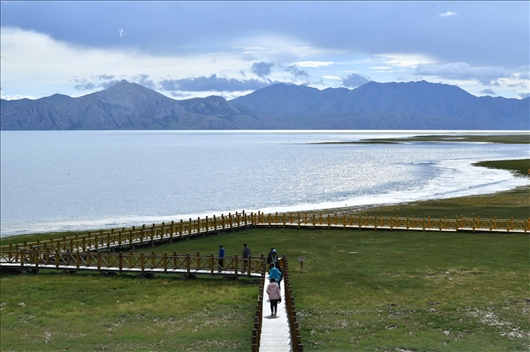 △ 游客行走在青?，敹嗫h冬格措納湖畔的木棧道上。