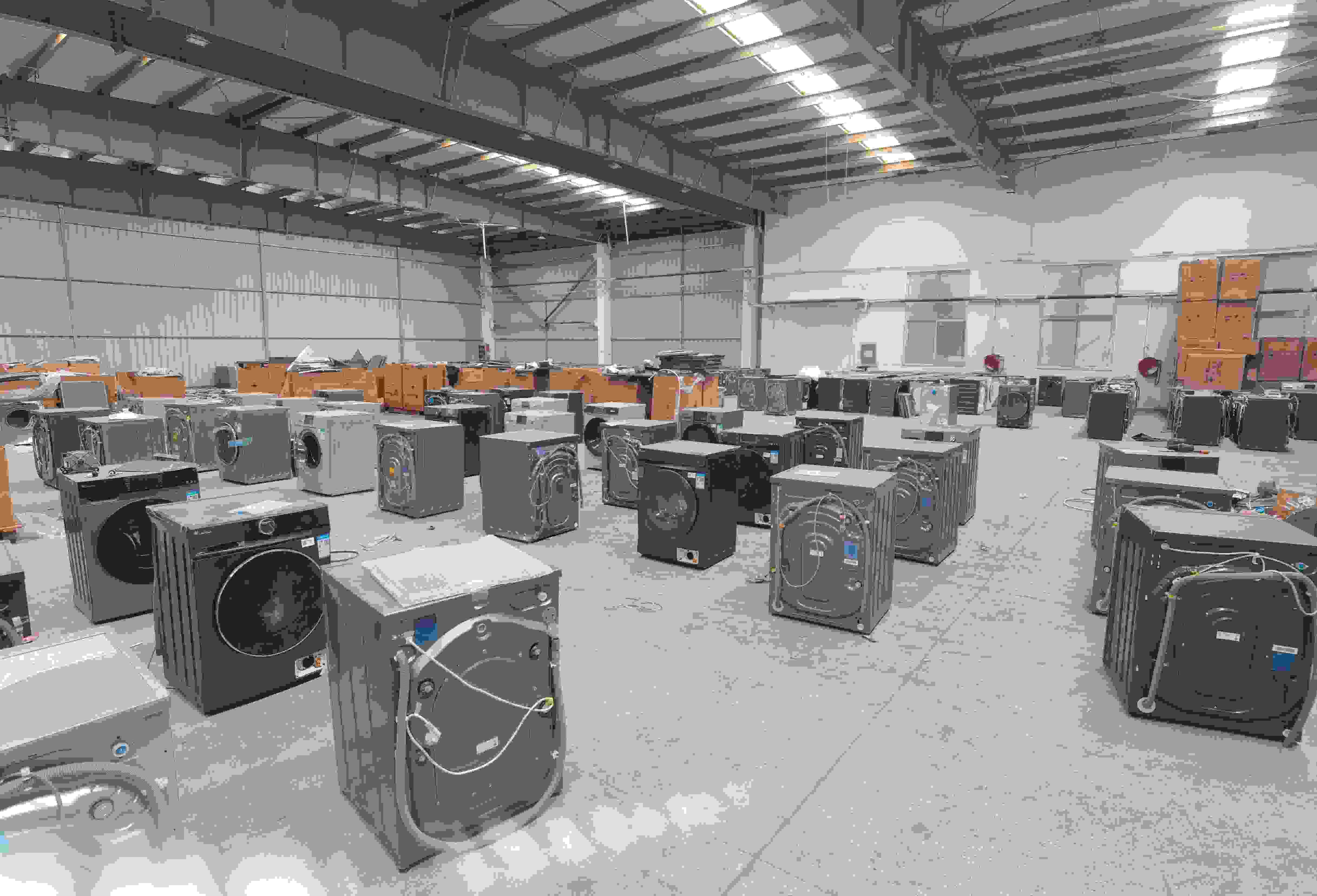 專(zhuān)案組民警查扣涉案場(chǎng)所及假冒知名品牌洗衣機(jī)。巨野警方供圖