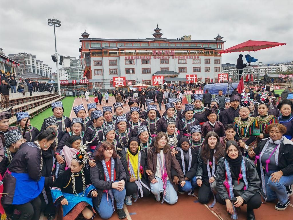 法國青年在“村超”賽場邊與參加表演的村民合影。新華社記者 羅羽 攝