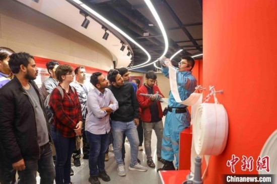 5月9日，工作人員指導(dǎo)留學(xué)生正確使用消防水帶。張鷹 攝