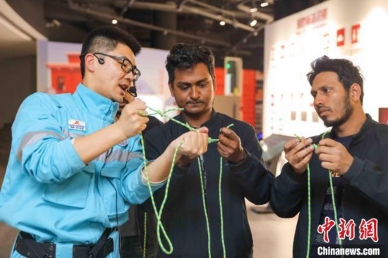 5月9日，工作人員指導(dǎo)留學(xué)生學(xué)習(xí)打繩結(jié)。張鷹 攝