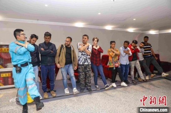 5月9日，工作人員指導(dǎo)留學(xué)生練習(xí)逃生技巧。張鷹 攝