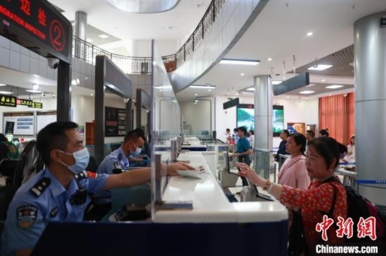 圖為旅客在磨憨口岸辦理通關(guān)手續(xù)。雷雨 攝