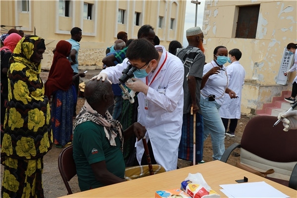 在義診現(xiàn)場，中國醫(yī)生與當(dāng)?shù)鼐用窈嫌傲裟?，吉布提鹽業(yè)投資公司供圖