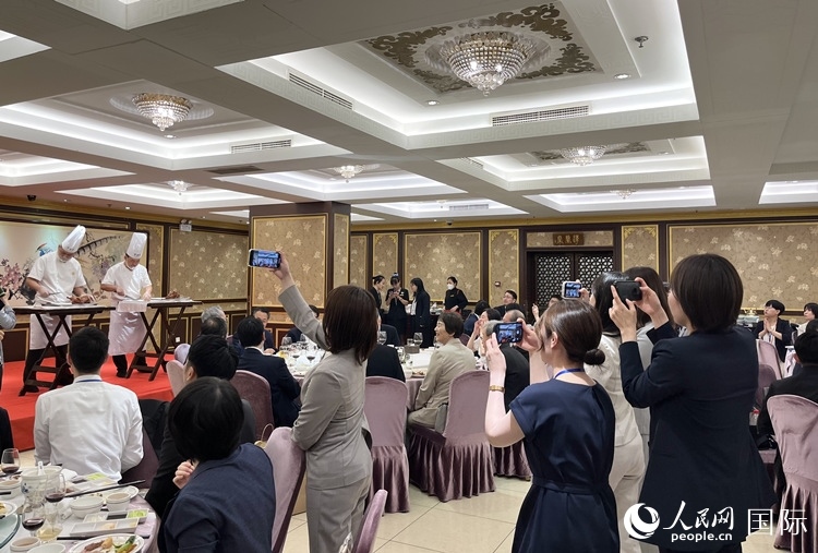 國(guó)家級(jí)非物質(zhì)文化遺產(chǎn)、全聚德片鴨工藝吸引代表團(tuán)成員拍照留念。