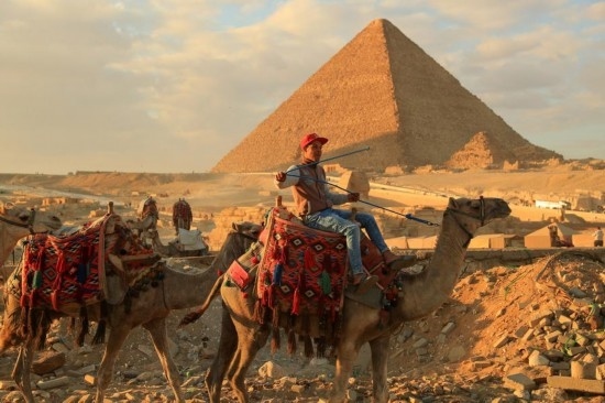 1月24日，商販騎駱駝離開埃及吉薩金字塔景區(qū)。新華社記者 隋先凱 攝