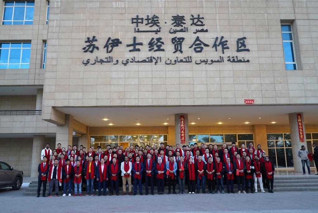 2024年2月11日，在位于埃及蘇伊士省的中?！ぬ┻_(dá)蘇伊士經(jīng)貿(mào)合作區(qū)，中埃員工在合作區(qū)辦公大樓前合影拜年。新華社發(fā)（泰達(dá)合作區(qū)供圖）