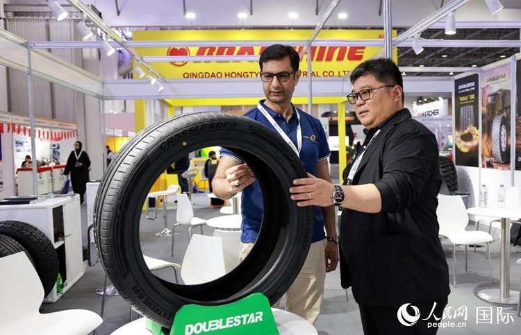 工作人員向客戶展示雙星電動汽車輪胎。和傳統(tǒng)汽車輪胎相比，電動汽車輪胎具有更高承載能力、更加靜音舒適、更好極速抓地、更低滾動阻力等特點。人民網(wǎng)記者 管克江攝