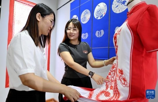 5月31日，在衡水市阜城縣一家剪紙工作室，游客在觀賞帶有剪紙元素的旗袍。